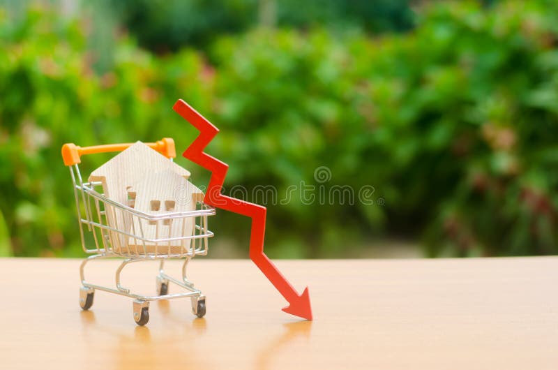Duas casas de madeira em um carro de troca e em uma seta vermelha para baixo mercado imobiliário de queda Interesse reduzido na h imagem de stock Duas casas de madeira em um carro de troca e em uma seta vermelha para baixo mercado imobiliário de queda Interesse reduzido na h imagem de stock