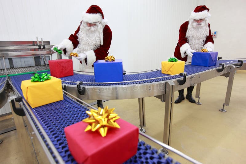 Duas cláusulas de Santa que trabalham na linha de produção imagens de stock Duas cláusulas de Santa que trabalham na linha de produção imagens de stock