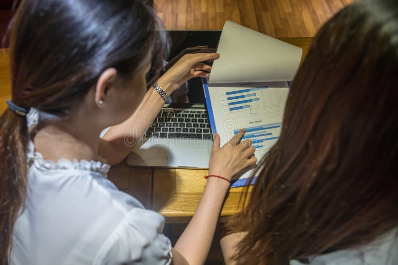 Duas contabilistas trabalhadoras trabalhando no documento gráfico no escritório de negócios fotos de stock Duas contabilistas trabalhadoras trabalhando no documento gráfico no escritório de negócios fotos de stock