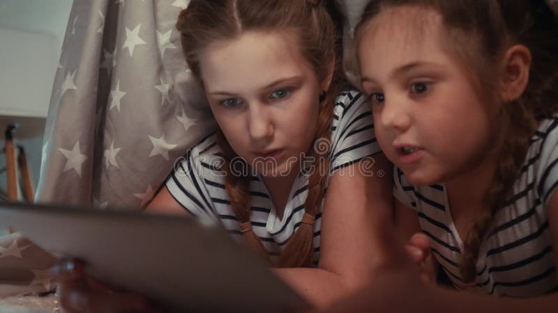 Duas Meninas No Sofá à Noite Com Uma Rede Digital De Tablet. Jogos Online  De Sonho Infantil a Conceito. Filhas Filme - Vídeo de junto, computador:  214846162