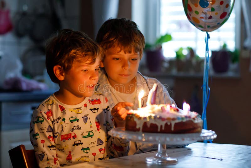 Duas crianças bonitas, meninos prées-escolar pequenos que comemoram o aniversário e que fundem velas imagem de stock royalty free Duas crianças bonitas, meninos prées-escolar pequenos que comemoram o aniversário e que fundem velas imagem de stock royalty free