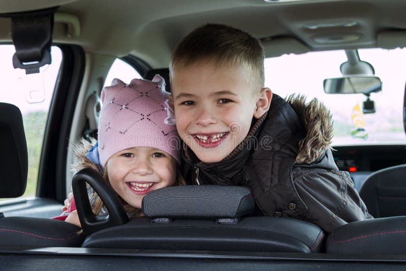 Duas crianças consideravelmente pequenas menino e menina em um interior do carro imagens de stock royalty free Duas crianças consideravelmente pequenas menino e menina em um interior do carro imagens de stock royalty free