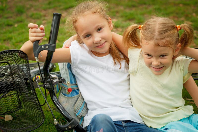 Duas crianças felizes em uma bicicleta imagens de stock Duas crianças felizes em uma bicicleta imagens de stock