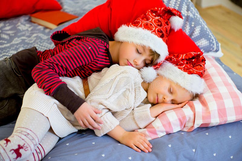 Duas crianças obtêm sonolentos até que esperarem o Natal foto de stock Duas crianças obtêm sonolentos até que esperarem o Natal foto de stock