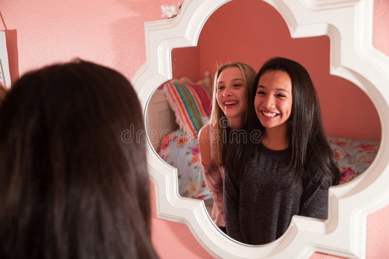 Duas lindas meninas olham no espelho