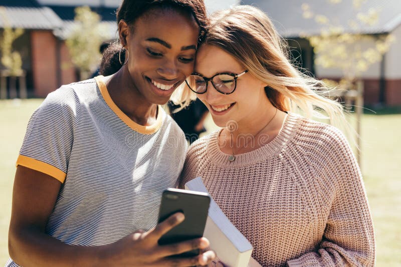 Duas meninas da High School com telefone celular fotos de stock royalty free Duas meninas da High School com telefone celular fotos de stock royalty free