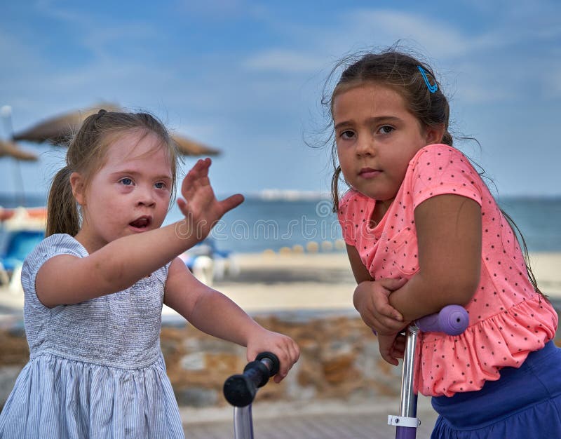Duas meninas em 'trotinette's pela praia fotos de stock Duas meninas em 'trotinette's pela praia fotos de stock
