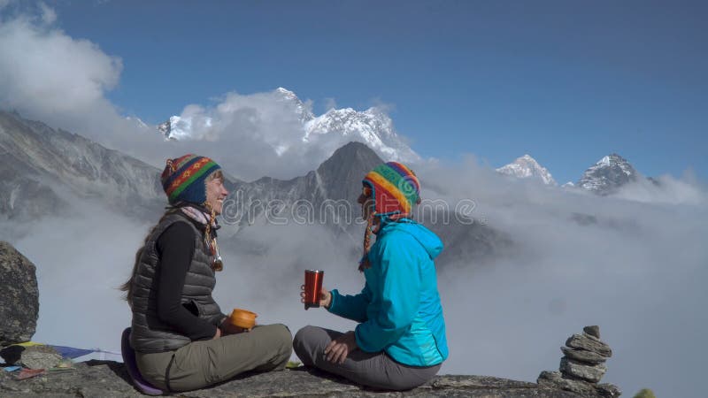 Duas meninas estão bebendo o chá nas montanhas