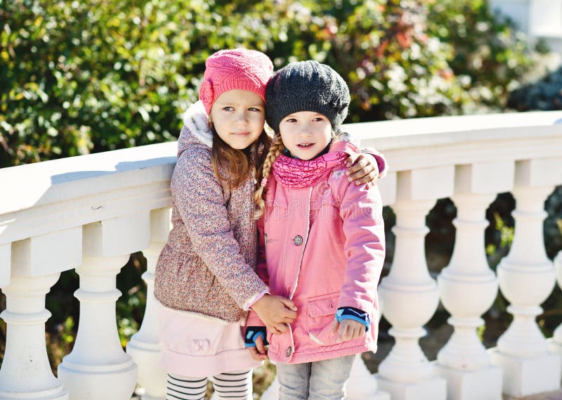 Duas meninas que abraçam fora fotos de stock royalty free Duas meninas que abraçam fora fotos de stock royalty free
