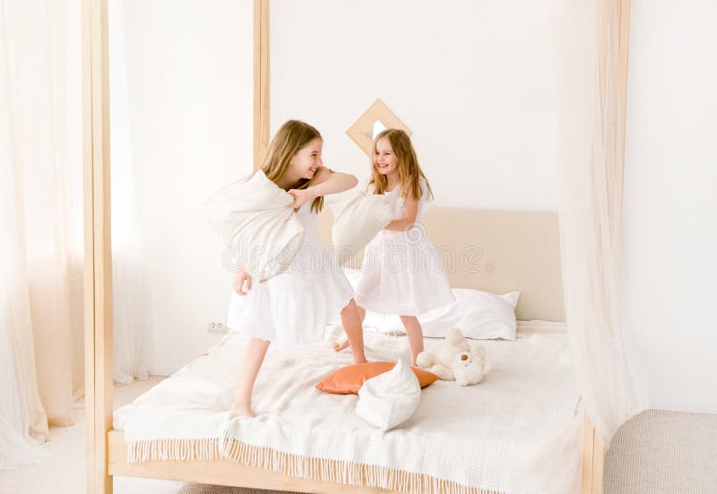 Duas Meninas Que Lutam Com Os Descansos Na Cama Foto De Stock Imagem De Casa Lazer 125324530 