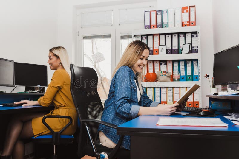 Duas mulheres alegres que trabalham com computadores fotos de stock Duas mulheres alegres que trabalham com computadores fotos de stock