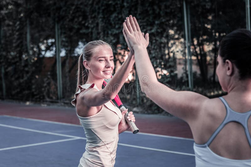 Duas mulheres energéticas que contestam no fósforo do tênis fotografia de stock Duas mulheres energéticas que contestam no fósforo do tênis fotografia de stock