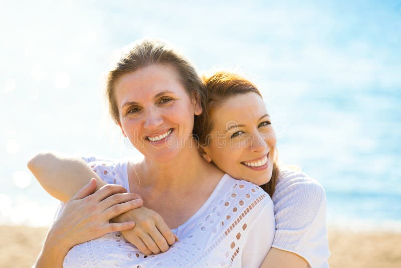 Duas mulheres mãe e filha do adulto que aprecia férias na praia
