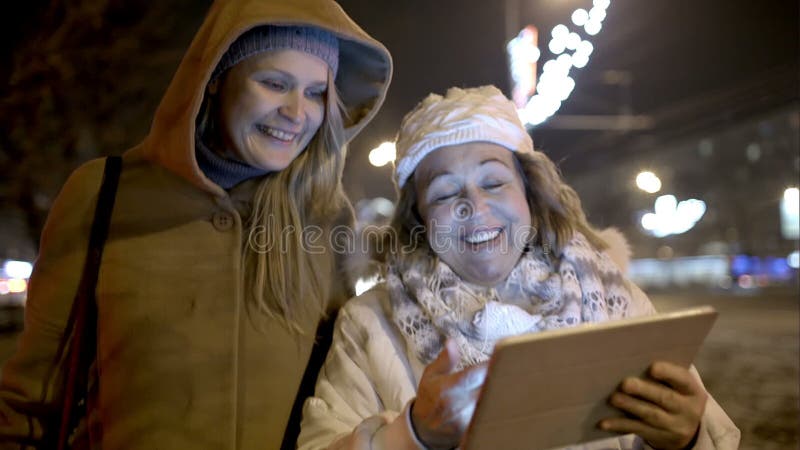 Duas mulheres que andam com a almofada exterior no frio