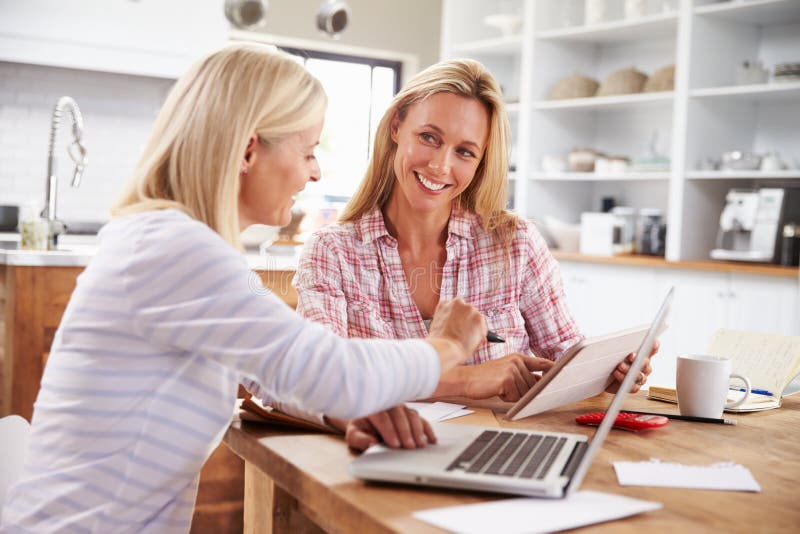Duas mulheres que trabalham junto em casa fotografia de stock royalty free Duas mulheres que trabalham junto em casa fotografia de stock royalty free