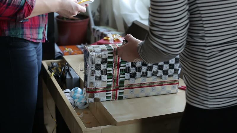 Duas mãos das mulheres estão embalando o presente vídeos de arquivo