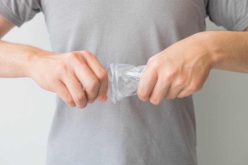 Duas mãos que torcem a garrafa plástica clara no fundo branco isolado e que incluem o trajeto de grampeamento, Resize a garrafa p fotografia de stock royalty free Duas mãos que torcem a garrafa plástica clara no fundo branco isolado e que incluem o trajeto de grampeamento, Resize a garrafa p fotografia de stock royalty free