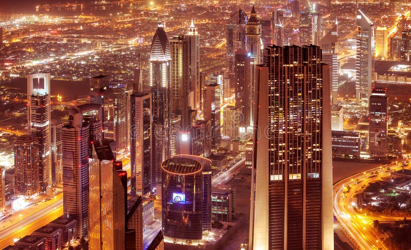 Dubai city at night, beautiful modern buildings glow lights, bird eye view on gorgeous cityscape, famous business and travel center, United Arab Emirates