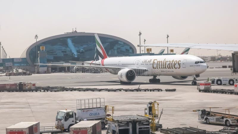 DUBAI, EMIRADOS ÁRABES UNIDOS AGOSTO, 22, 2016: o pushback de emirados de um Boeing 777 aplana em Dubai fotografia de stock DUBAI, EMIRADOS ÁRABES UNIDOS AGOSTO, 22, 2016: o pushback de emirados de um Boeing 777 aplana em Dubai fotografia de stock
