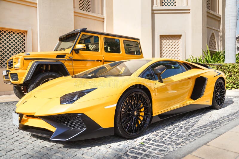 DUBAI, UAE - JANUARY 08, 2019: yellow luxury supercar Lamborghini Aventador Roadster and Gelandewagen in Dubai. DUBAI, UAE - JANUARY 08, 2019: yellow luxury supercar Lamborghini Aventador Roadster and Gelandewagen in Dubai.
