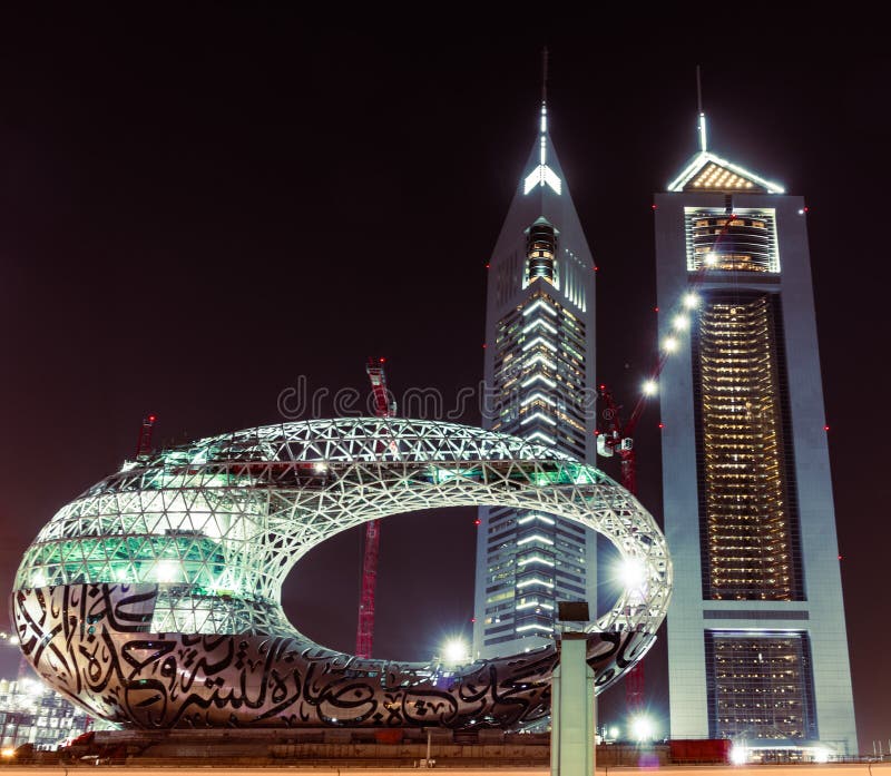 Dubai, United Arab Emirates; modern museum of the future under construction, Emirates Towers at night.