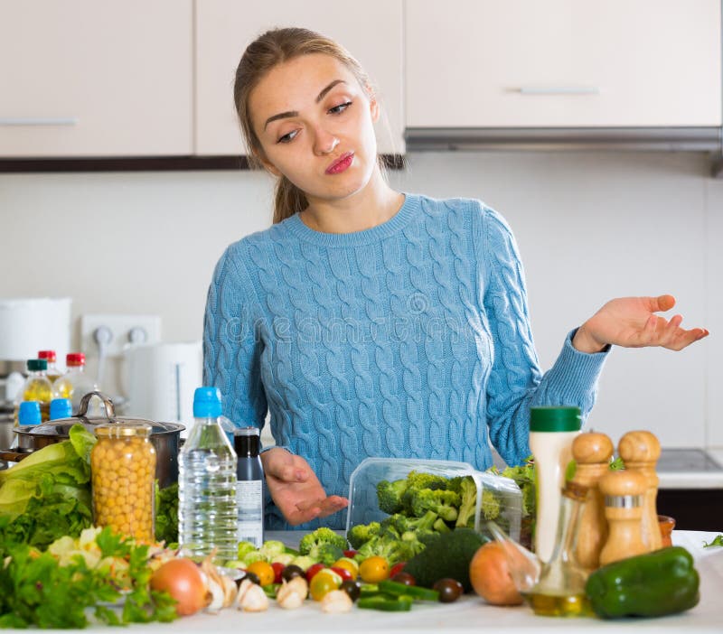 Dubbio della ragazza che pensa che cosa cucinare per la cena immagini stock libere da diritti Dubbio della ragazza che pensa che cosa cucinare per la cena immagini stock libere da diritti
