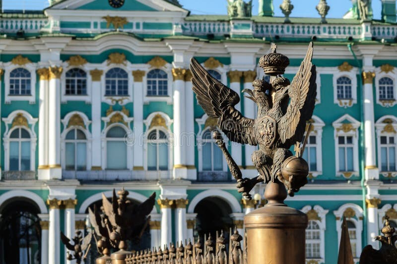 Dubblett-hövdad örn i den imperialistiska kronan på bakgrunden av eremitboningen (vinterslott) i St Petersburg royaltyfri fotografi Dubblett-hövdad örn i den imperialistiska kronan på bakgrunden av eremitboningen (vinterslott) i St Petersburg royaltyfri fotografi