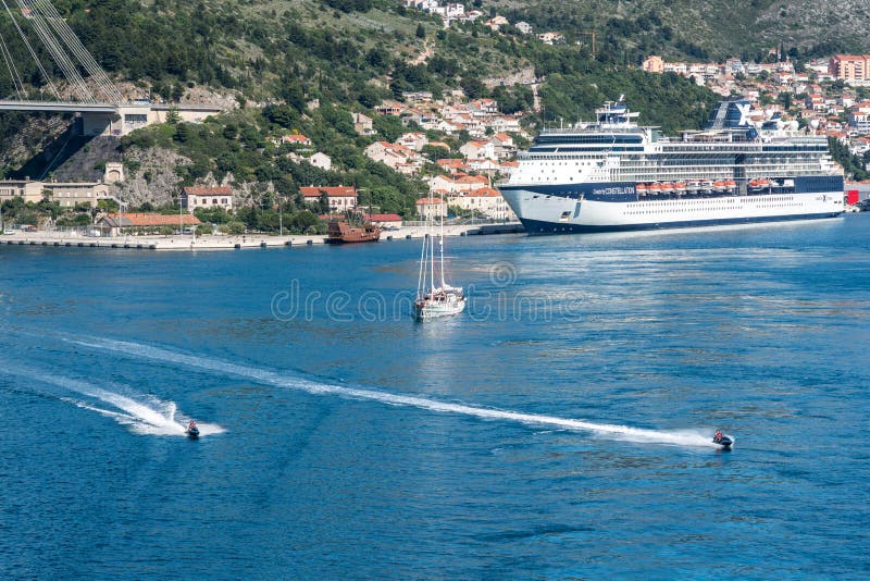 Dubrovnik, Croatia - 22 May 2019: Wave runners follow cruise ship leaving the Dubrovnik cruise port near the old town. Dubrovnik, Croatia - 22 May 2019: Wave runners follow cruise ship leaving the Dubrovnik cruise port near the old town