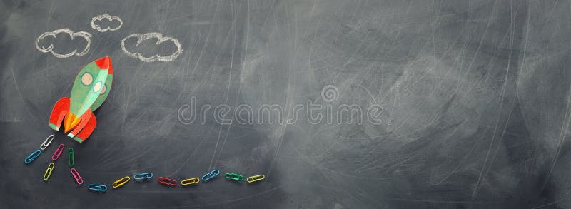 Education. Back to school concept. rocket cut from paper and painted over blackboard background. top view, flat lay. banner. Education. Back to school concept. rocket cut from paper and painted over blackboard background. top view, flat lay. banner.