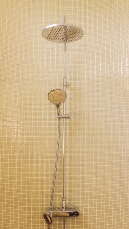 Una habitación de ducha con un cabezal de ducha de lluvia y acentos de  mosaico
