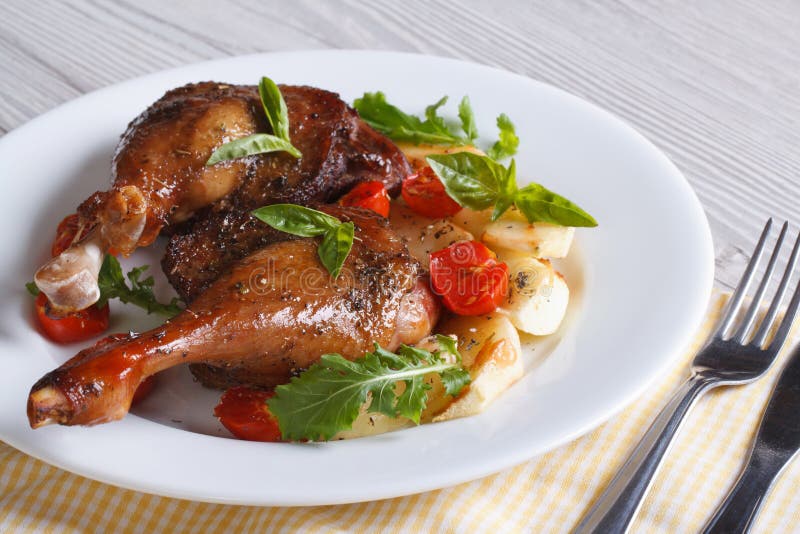 Duck legs roasted with apples, tomatoes and herbs horizontal