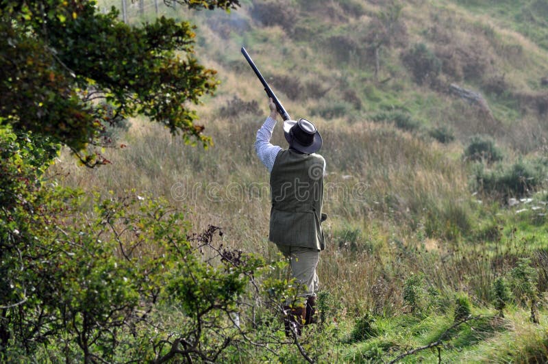 Man in a field at a duck shoot shooting ducks with shotgun royalty free stock image Man in a field at a duck shoot shooting ducks with shotgun royalty free stock image