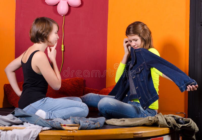Due adolescenti alla moda che scelgono i vestiti immagine stock libera da diritti Due adolescenti alla moda che scelgono i vestiti immagine stock libera da diritti