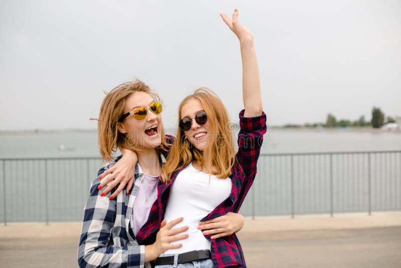 Due amici femminili sorridenti che si abbracciano sulla via Concetto di feste, di vacanza, di amore e di amicizia fotografia stock libera da diritti Due amici femminili sorridenti che si abbracciano sulla via Concetto di feste, di vacanza, di amore e di amicizia fotografia stock libera da diritti
