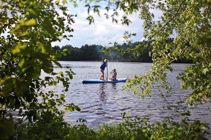 Due bambine che viaggiano in un lago su un lago in una giornata estiva fotografie stock