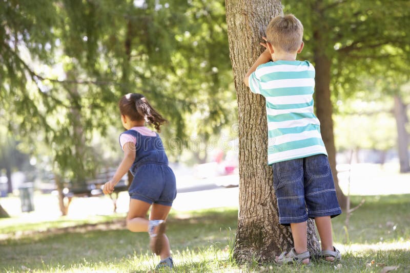 Due bambini che giocano nascondino in parco