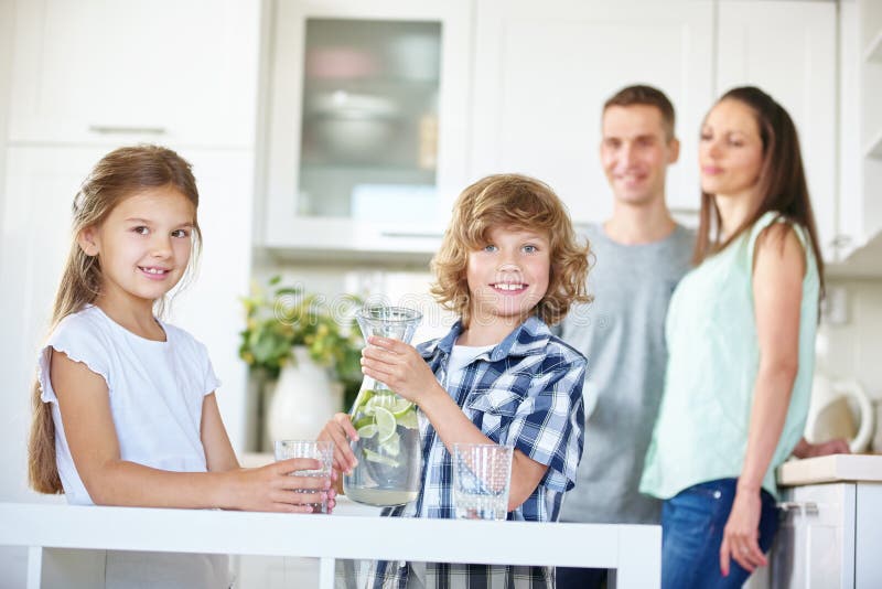 Due bambini con la caraffa piena di acqua dolce fotografie stock Due bambini con la caraffa piena di acqua dolce fotografie stock
