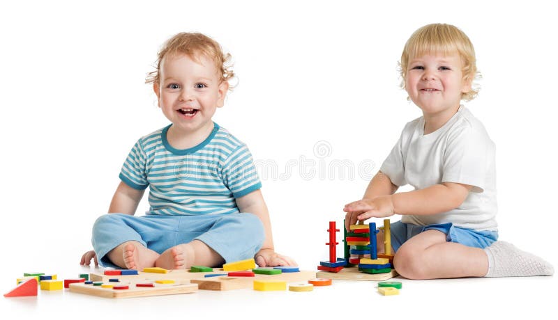 Due bambini felici che giocano i giocattoli logici immagine stock Due bambini felici che giocano i giocattoli logici immagine stock