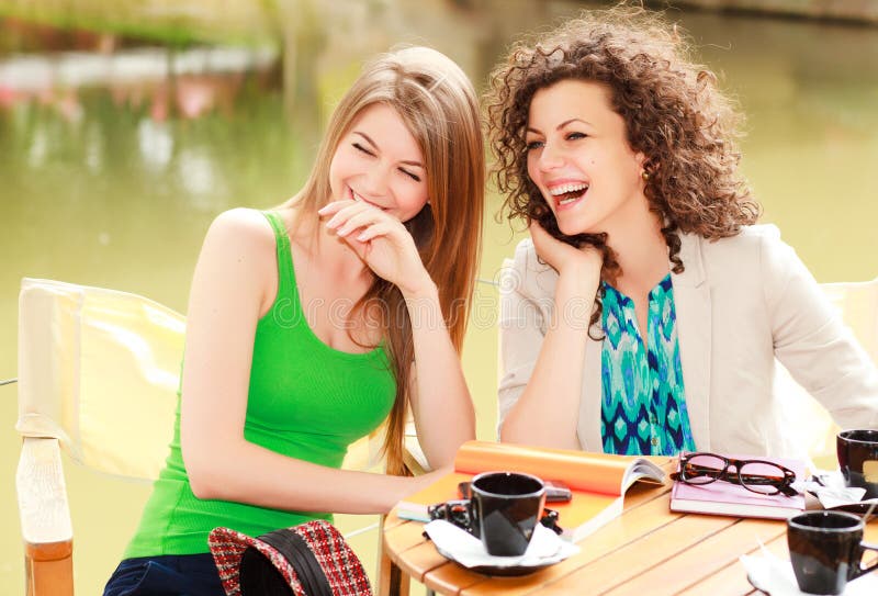 Due belle donne che ridono sopra un cofee