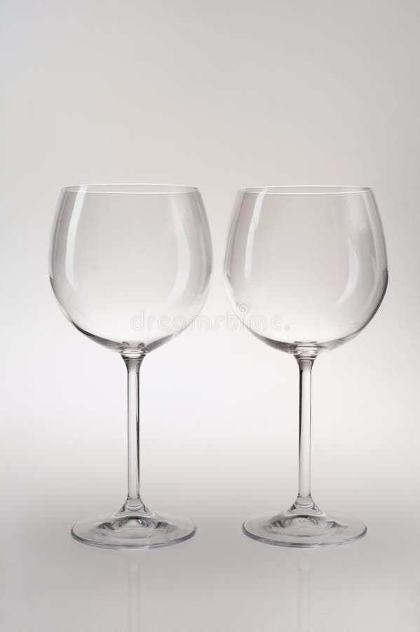 Due bicchieri di vino eleganti isolati su priorità bassa grigia