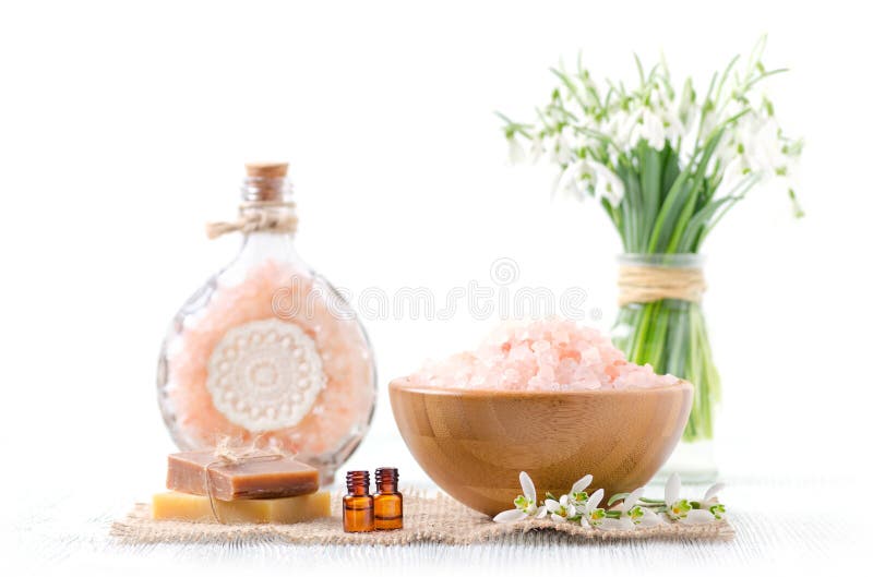 Due bottiglie con olio essenziale organico con i fiori freschi di bucaneve, sapone, sale himalayano su vecchio fondo di legno e b fotografia stock libera da diritti Due bottiglie con olio essenziale organico con i fiori freschi di bucaneve, sapone, sale himalayano su vecchio fondo di legno e b fotografia stock libera da diritti