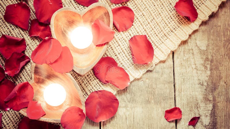 Due candele chiarite in candelieri in forma di cuore con sono aumentato immagine stock libera da diritti Due candele chiarite in candelieri in forma di cuore con sono aumentato immagine stock libera da diritti