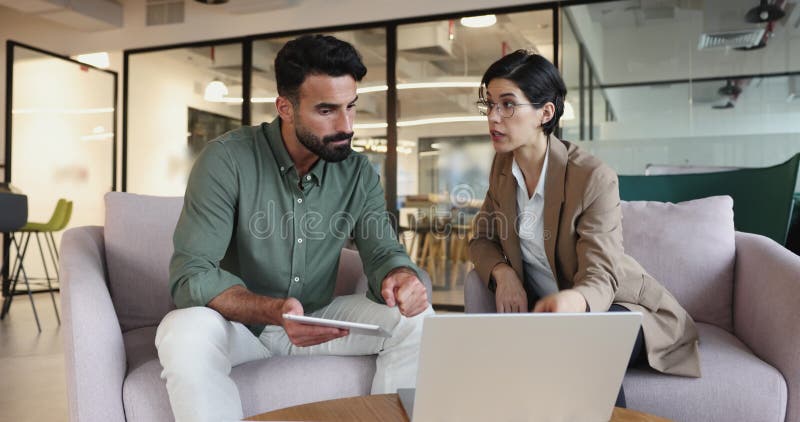 Due colleghi che collaborano in ufficio con un laptop stock footage