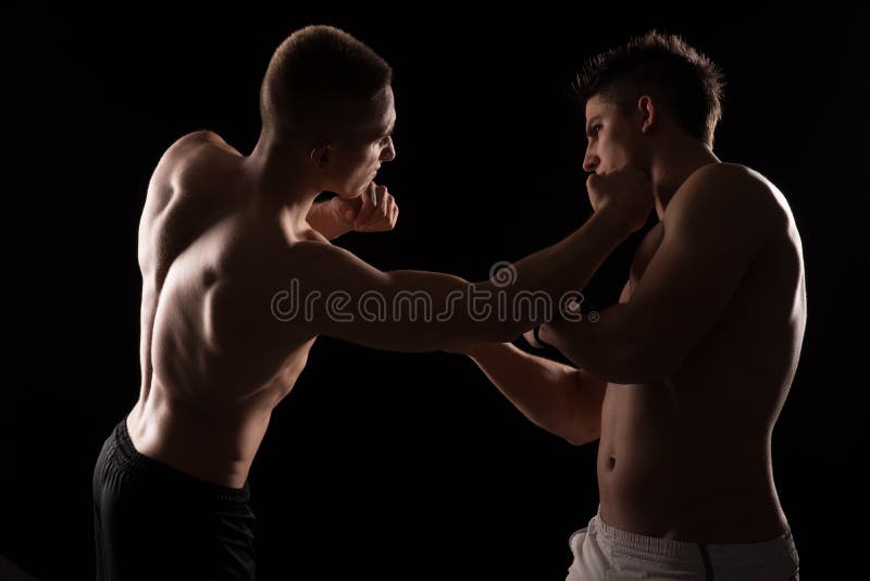 Due combattenti che si affrontano su fondo nero fotografia stock libera da diritti