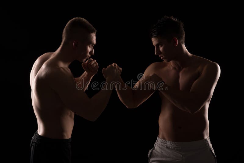 Due combattenti che si affrontano su fondo nero immagine stock libera da diritti