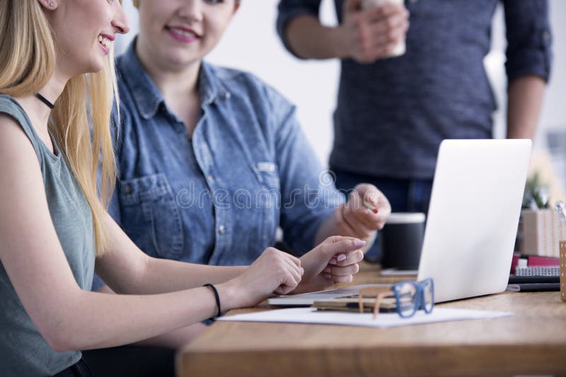 Due donne che si siedono con il computer portatile immagine stock libera da diritti Due donne che si siedono con il computer portatile immagine stock libera da diritti
