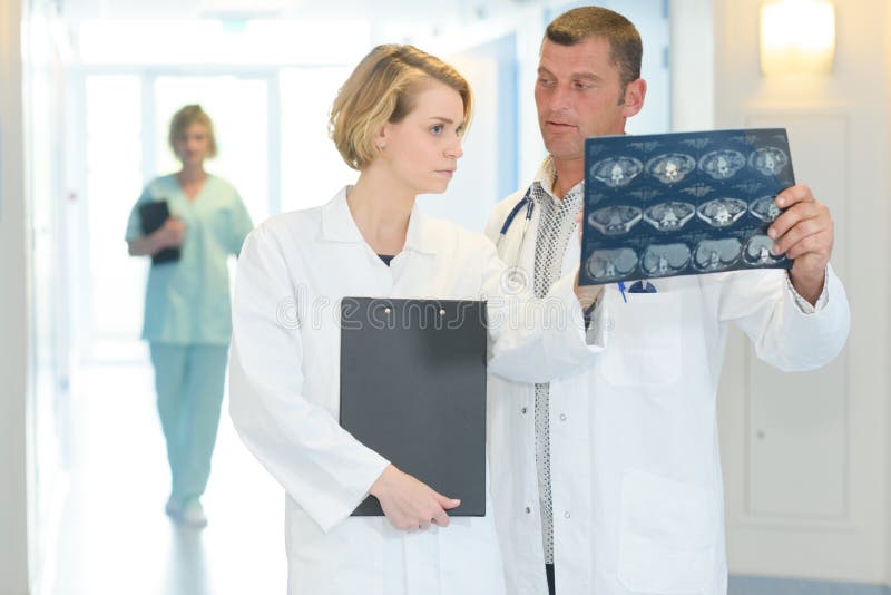 Due erbe mediche con la ricerca dei raggi x della spina dorsale all'ospedale fotografia stock libera da diritti Due erbe mediche con la ricerca dei raggi x della spina dorsale all'ospedale fotografia stock libera da diritti
