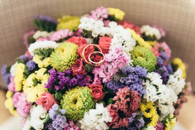 Due fedi nuziali si trovano su un mazzo dei fiori secchi immagine stock Due fedi nuziali si trovano su un mazzo dei fiori secchi immagine stock
