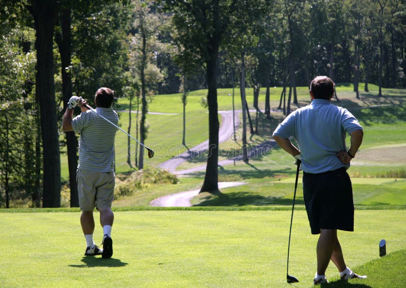 Due giocatori di golf sul couse di golf immagini stock libere da diritti Due giocatori di golf sul couse di golf immagini stock libere da diritti