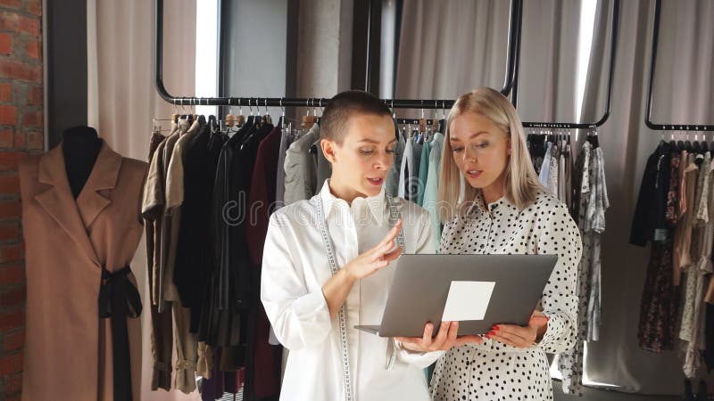 Due giovani donne caucasiche guardano il computer portatile e ne parlano entusiasticamente